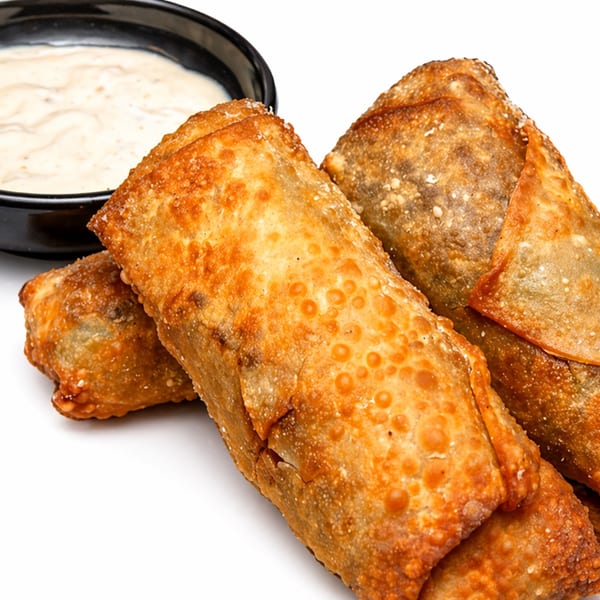Three crispy, golden-brown egg rolls with a side of creamy dipping sauce in a black bowl.